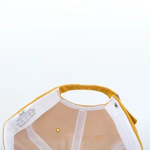Close-up of yellow cotton baseball cap showing internal stitching and adjustable strap