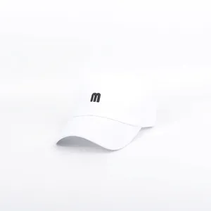 Detailed view of 3D black embroidered letter M on a white cotton baseball cap