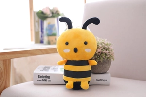 Close-up of cute plush bee toy with yellow and black stripes on a cozy chair