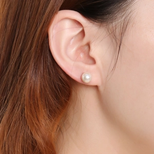 Elegant white round pearl stud earring on model showing natural luster and professional finish
