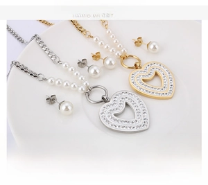 Detailed view of heart-shaped zircon necklace and pearl earrings set in stainless steel