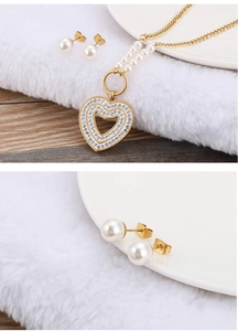 Detail view of heart-shaped rhinestone pendant with white pearls and gold stud earrings