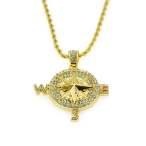 Detail of gold compass pendant with sparkling crystals on a twist rope chain necklace