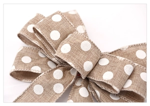 Close-up of rustic beige burlap bow with white polka dots for Christmas tree decoration