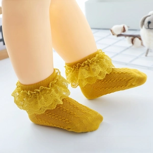 Detail of yellow cotton baby socks with double-layered lace and breathable mesh knit