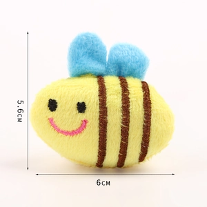Close-up detail of a yellow plush bee brooch with dimensions 5.6cm by 6cm