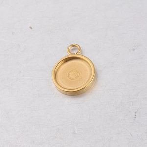 Detailed macro view of a golden stainless steel round pendant tray with top jump ring