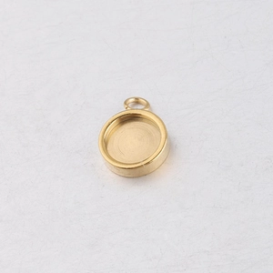 Close-up of a golden stainless steel round pendant base for DIY jewelry making