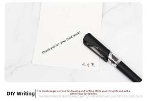 Detail of a minimalist black pen writing smoothly on a white gift card over marble surface