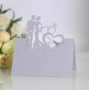 Detail of laser-cut Mr & Mrs lilac pearl paper wedding place card with heart silhouette