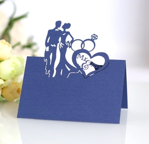 Macro detail of laser-cut navy blue wedding place card with Mr & Mrs silhouette