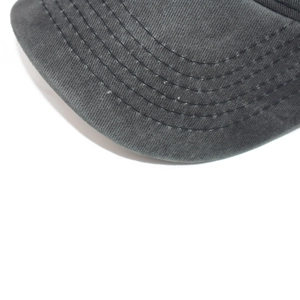 Close-up of dark grey washed cotton baseball cap featuring reinforced multi-row brim stitching