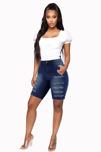 Detail von dunkelblauen High-Waist Denim-Shorts mit Distressed-Rissen und Whiskers-Effekt
