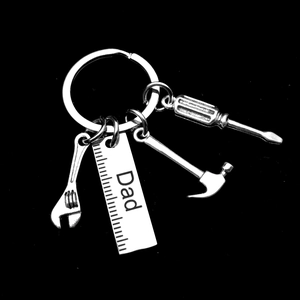 Detailed view of metal tool keychains with hammer and ruler engraved with Dad text