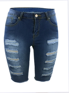Detailansicht des ausgefransten Saums und der Distressed-Denim-Textur der blauen Jeans