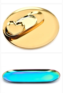 Detail of polished stainless steel trays in golden and rainbow finishes for home decor