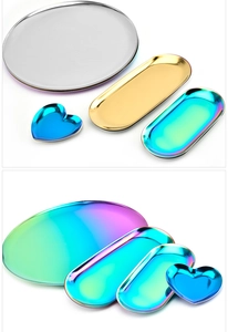 Macro shot of oval and heart-shaped stainless steel metal trays in gold and rainbow finishes