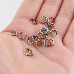 Close-up of rainbow vacuum-plated stainless steel open jump rings on palm for DIY jewelry