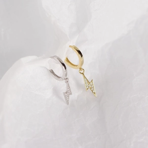 Macro detail of lightning bolt hoop earrings in gold and silver finish with cubic zirconia