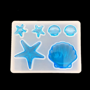 Detail van siliconen mallen voor zeesterren en schelpen met blauwe harsvulling