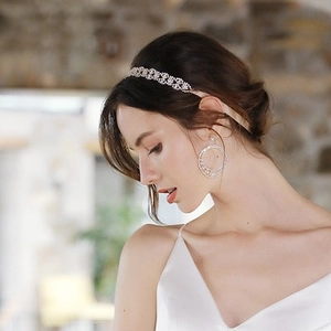 Elegante cerchietto da sposa con strass e orecchini tondi indossati da una modella in luce