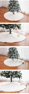 Close-up of white plush Christmas tree skirt featuring silver sequined snowflake embroidery