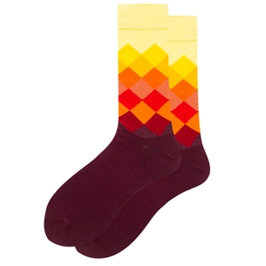 Macro shot of knitted mid-calf socks with gradient argyle pattern from yellow to burgundy