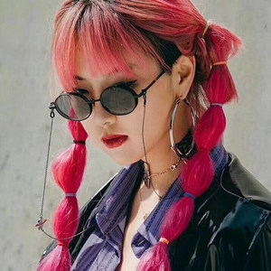 Detail of retro round sunglasses with metal saturn pendant chain on pink-haired model