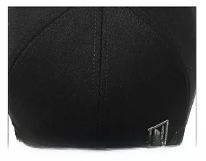 Detail of multi-panel stitching and silver embroidered letter N on black baseball cap