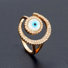 Macro view of golden evil eye ring with sparkling crystals and crescent moon detail