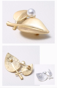 Detail of matte gold and silver leaf brooches with elegant white pearl accents