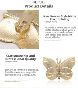 Detailed view of matte gold butterfly brooch with inlaid white rhinestones and secure pin