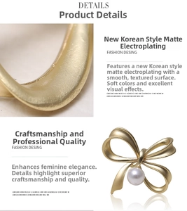 Detail of matte gold bow brooch featuring a white faux pearl and brushed alloy texture