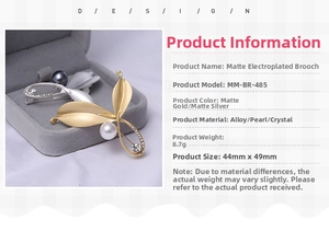 Detail of matte gold leaf brooch with white pearl and rhinestone in a gray jewelry box