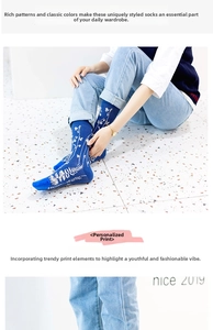 Detail of blue mid-calf socks with white fern print patterns worn in a casual setting