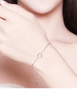 Close-up of a minimalist S925 sterling silver hollow heart pendant bracelet on a wrist