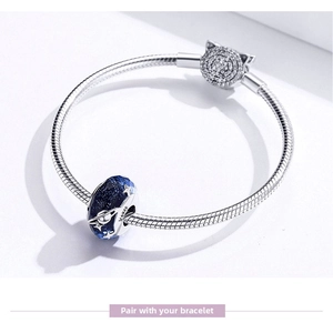 Macro detail of S925 silver snake chain bracelet with blue planet bead and cat clasp
