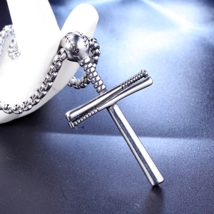 Détail macro du pendentif croix en bâton de baseball en acier inoxydable argenté