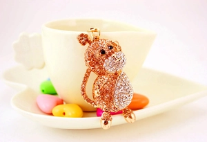 Detailed view of a gold monkey keychain featuring intricate sparkling crystals on a cup