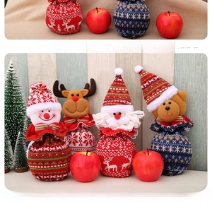 Détail de quatre sacs de Noël en tricot avec motifs de Père Noël, renne, bonhomme de neige