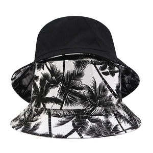 Reversible canvas bucket hat with coconut tree print and solid black outdoor sun protection