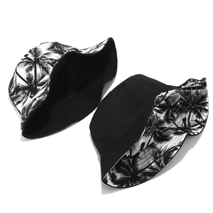 Reversible canvas bucket hat featuring tropical palm tree print and solid black design