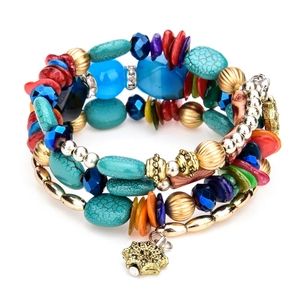 Detalle de una pulsera bohemia de varias capas con piedras turquesas y estrella