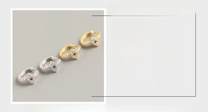 Detail of S925 sterling silver evil eye earrings with blue stones in gold and silver