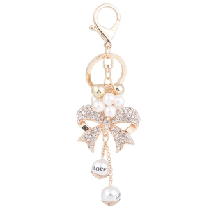 Golden keychain with rhinestone bow and white pearl pendant featuring a LOVE charm