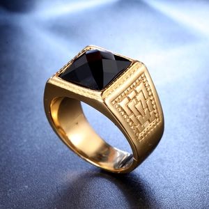 Macro shot of men's gold ring featuring a black pyramid gemstone and vintage textures