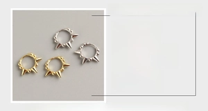 Detail of S925 sterling silver rivet hoop earrings in white gold and yellow gold finishes