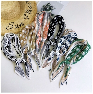 Detailed view of pleated polka dot scarves stacked neatly in various vibrant colors