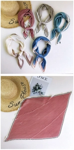 Detailed view of pleated satin scarves with contrasting zig-zag edges in various colors