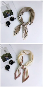Detail of pleated silk scarves in khaki and cream white with elegant contrasting borders